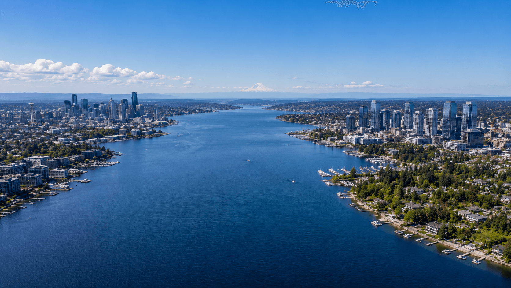 Aerial view of Lake Washington on a clear day with the Seattle skyline visible on the west shore and the Bellevue skyline on the east